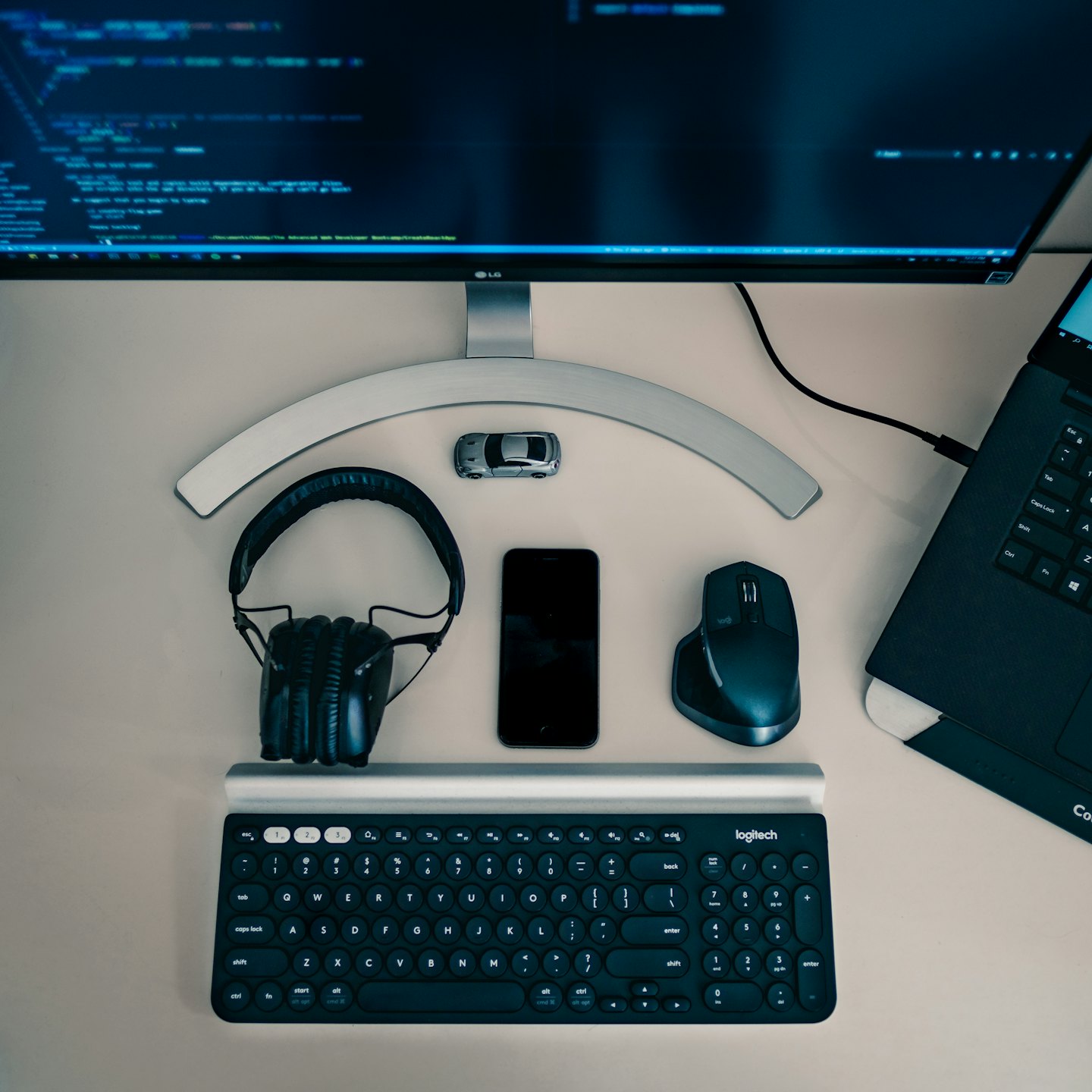 Una moderna scrivania tecnologica con un monitor che mostra codice e diversi dispositivi.